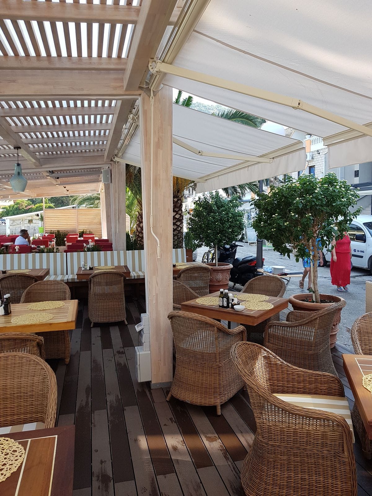 Pergola od letvica koja stvara hlad nad terasom restorana
